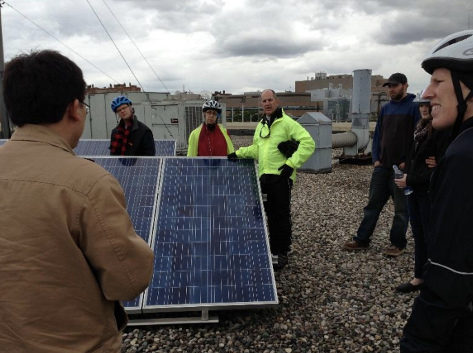 Several people gathered around a solar pannel array